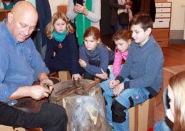 Schmied und Metallkünstler Olaf Hannemann erklärt den Kindern die Technik der Metallbearbeitung (Foto: Babett Wiechmann)